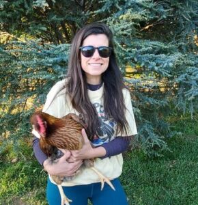 Girl blogger in sunglasses holding a chicken