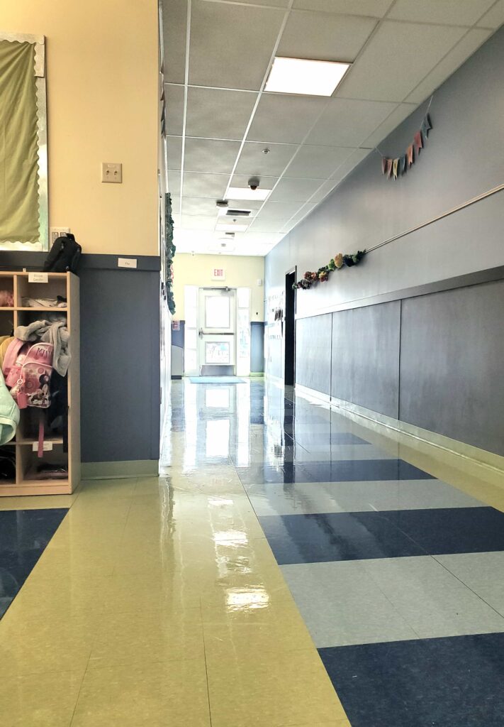 Blue and yellow hallway in school with EXIT sign (the obvious choice)